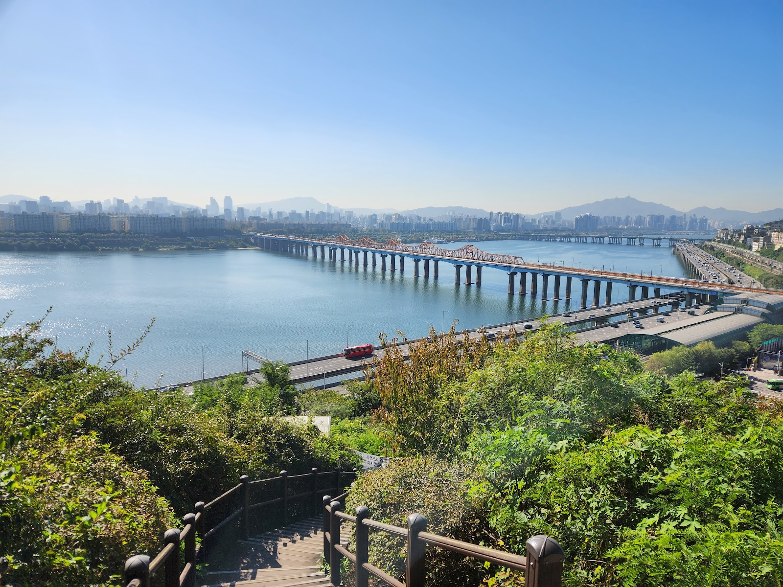 春の丘の上から望むソウルの市街地 — ナクサンの展望台から見える景色に似た、都市の水平線が広がるパノラマ