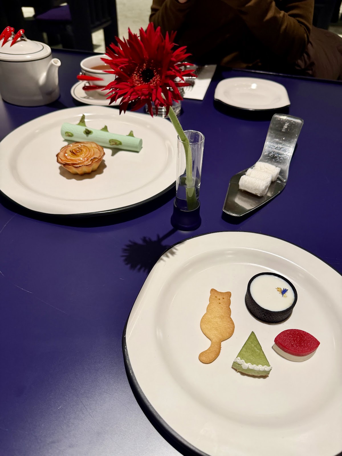 NUDAKE — 深蓝桌面上精致摆盘的甜品